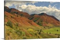 2407 Rolling red hills under a cloudy blue sky during the summer in rural