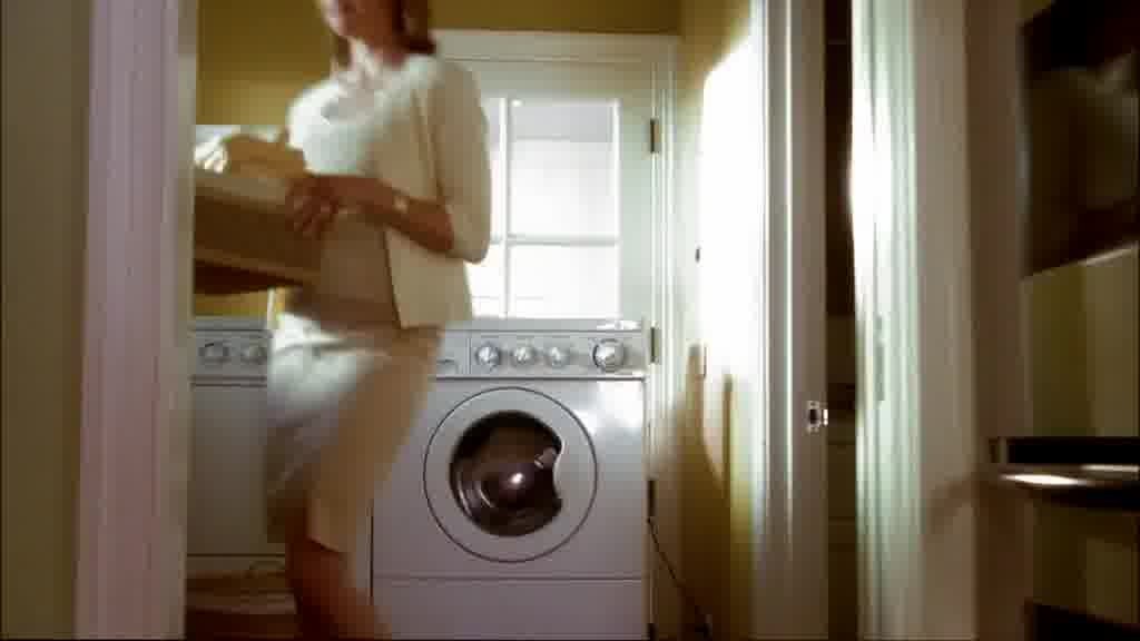 She lifts a basket of clothing off the machine.jpg