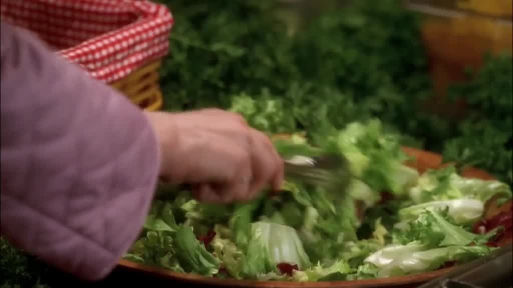 BREE puts some lettuce leaves on the plate as MRS. HUBER comes up to her.jpg