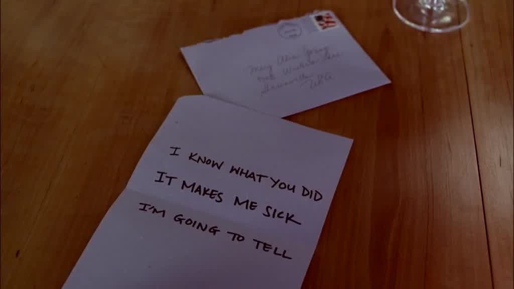 The camera pans to show the threatening letter.jpg