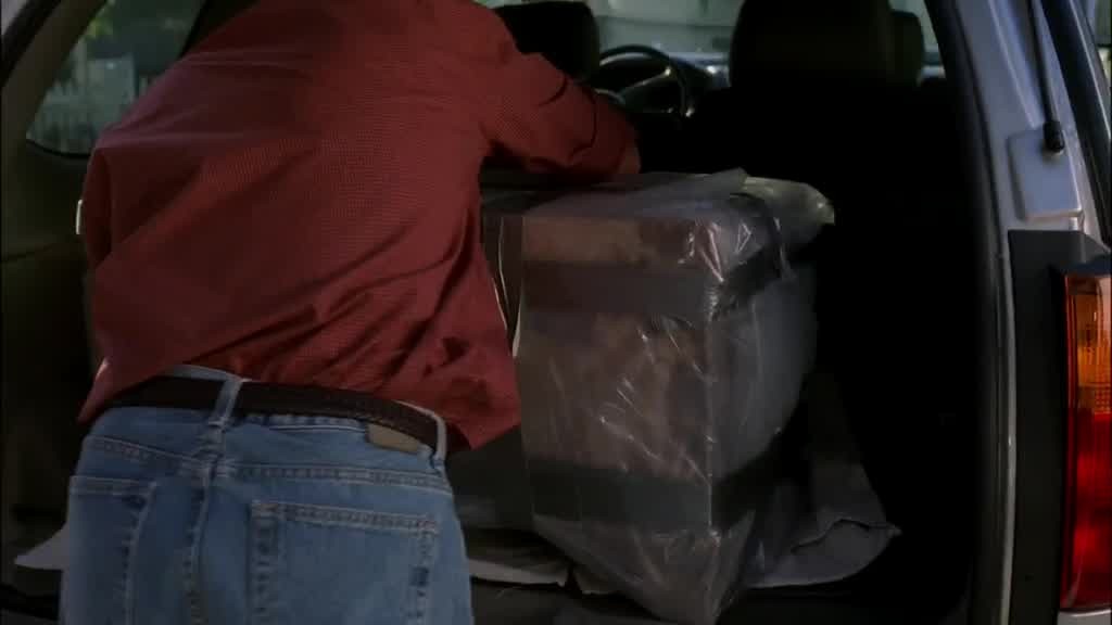 He pulls the box away from SUSAN as he heaves it into the open trunk of his car.jpg