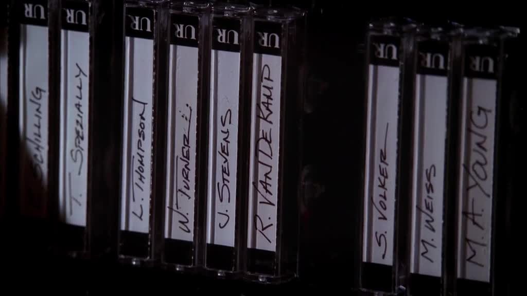 She looks through the tapes marked with names of DR. GOLDFINE's clients.jpg