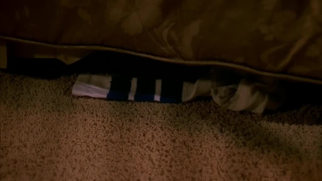 The shot pans down and we see one of John's socks left under the bed.jpg