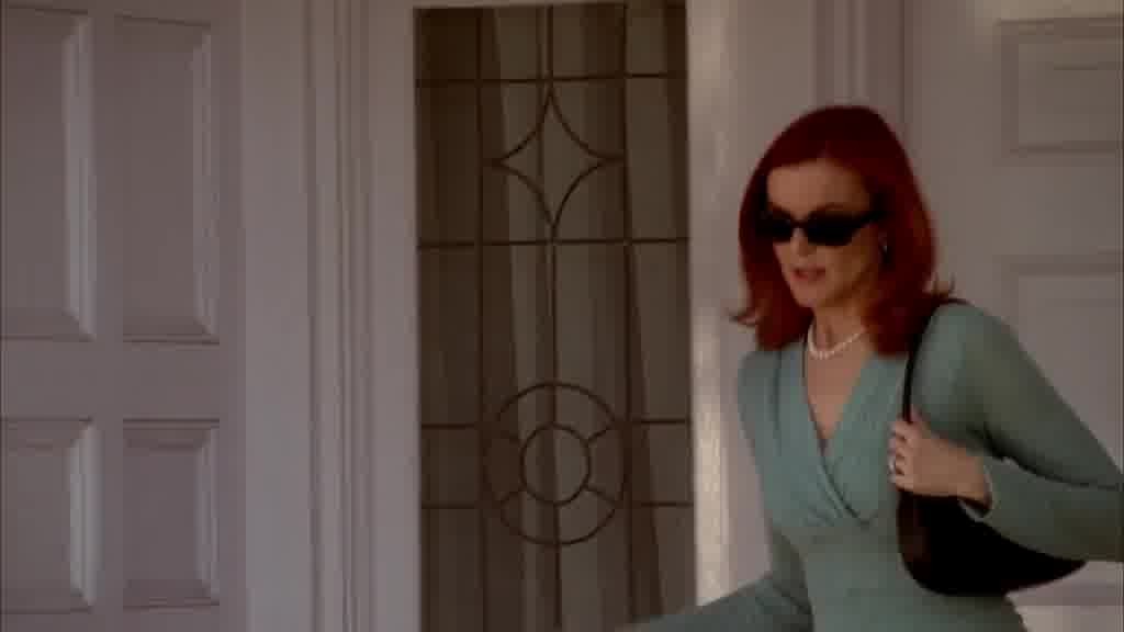 Bree is leaving her house, wearing dark sunglasses.jpg