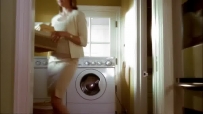 S01E01 She lifts a basket of clothing off the machine