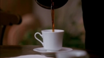 S01E01 She picks up the coffee pot, and starts pouring coffee into a mug